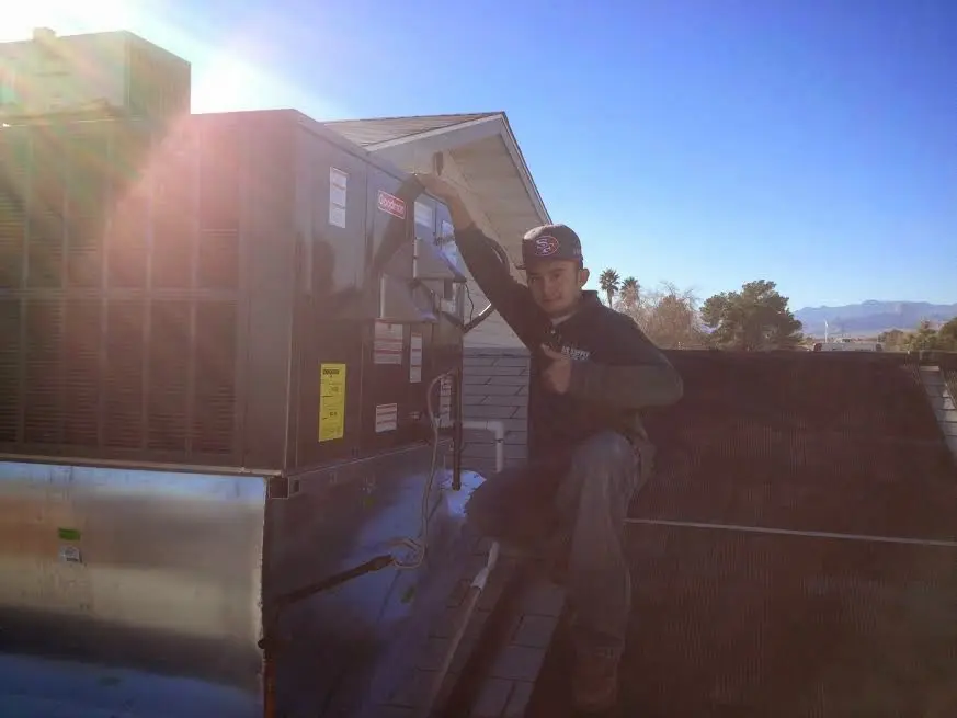 HVAC technician performing Boiler Repair on a rooftop unit in Mansfield